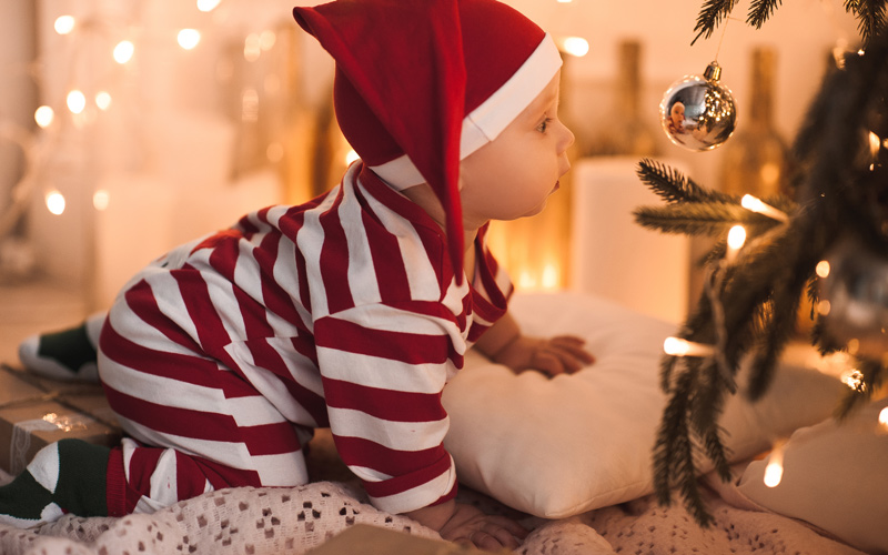 Bebé junto al árbol de Navidad